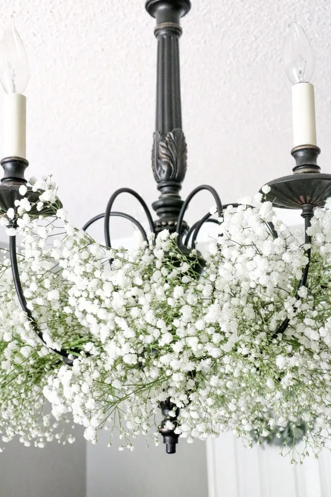 Decorate a chandelier with baby's breath flowers.
