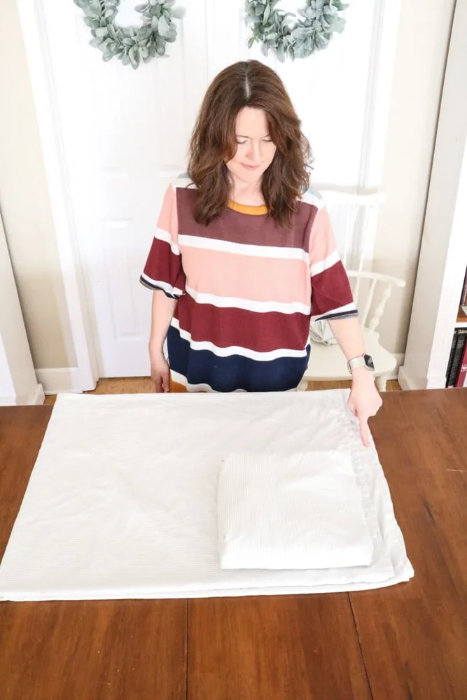 How to fold bed sheets neatly by placing the folded fitted sheet into the corner of the flat sheet.