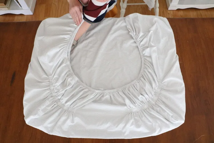 How to fold bed sheets neatly by laying the corners down on the table and making a square. 