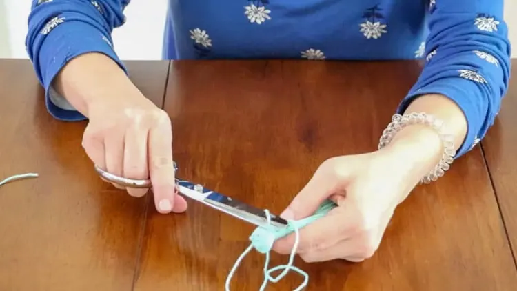 How to make a tassel with yarn by snipping the piece of yarn hanging out.