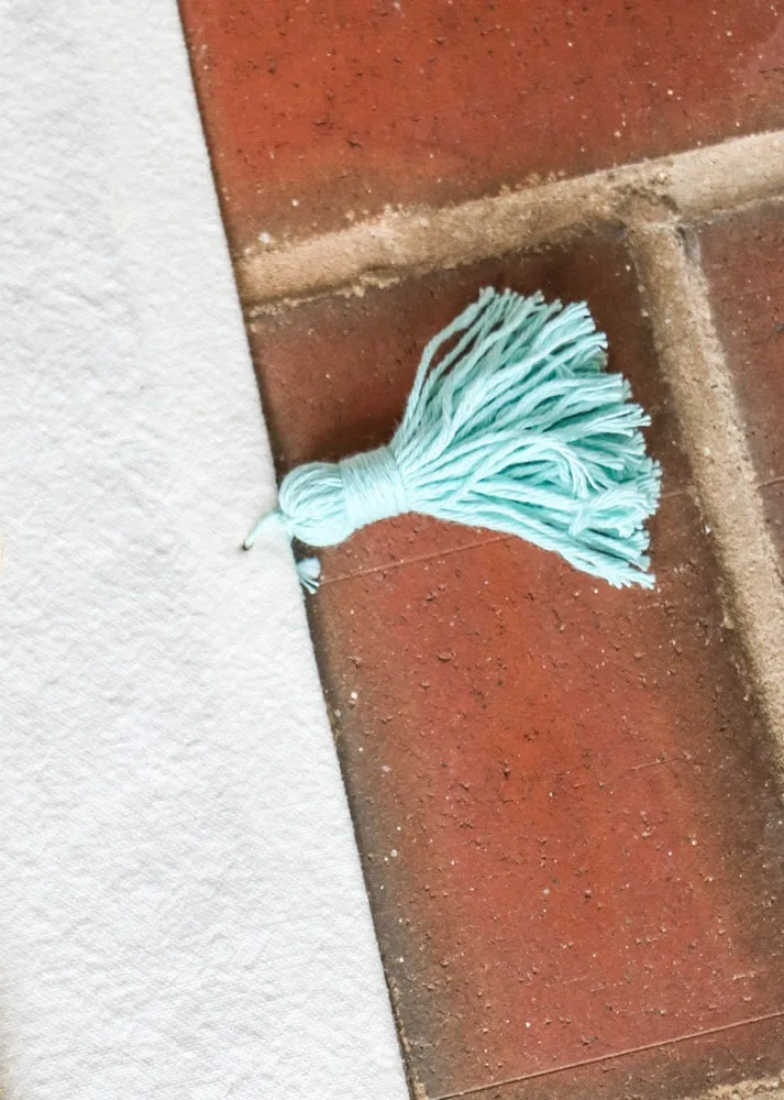 How to make a tassel with yarn example of a light teal tassel.