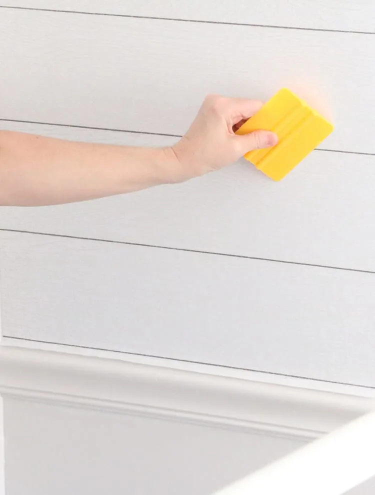 How to apply peel and stick wallpaper on an accent wall with a shiplap wall covering.