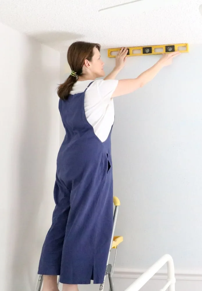 How to install peel and stick wallpaper by making sure the ceiling and wall are level first.
