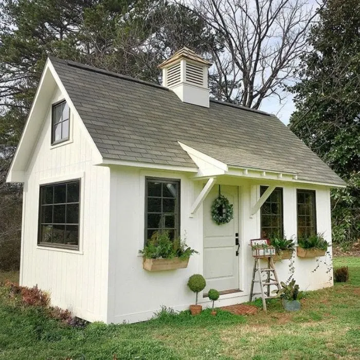 A white gardening she shed by Vintage Brick House