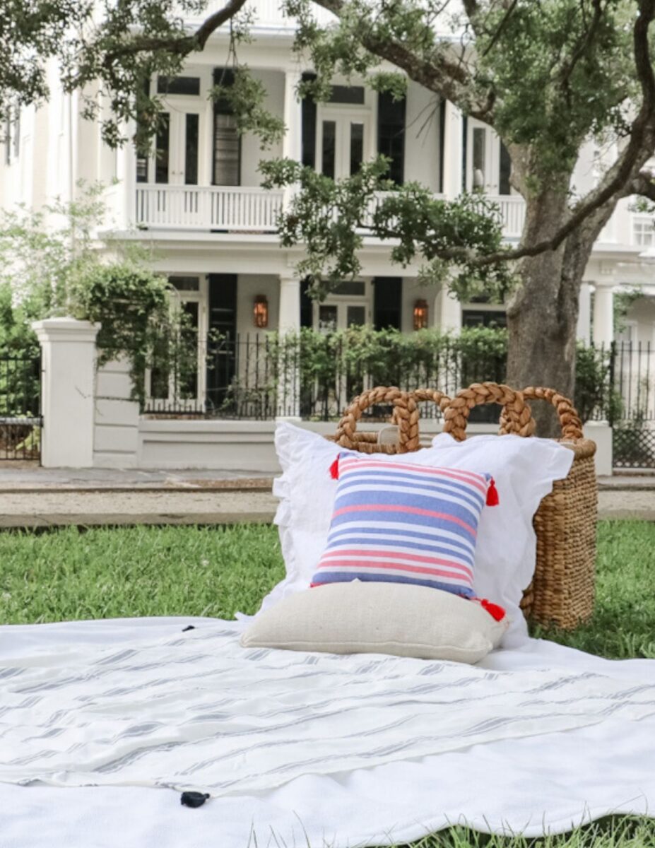 Patriotic picnic ideas using layered blankets on the ground, stacking pillows up against baskets.