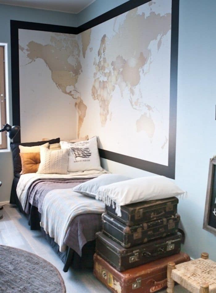 Cool ideas for dorm rooms with a large oversized wall map and vintage suitecases stacked on the floor.