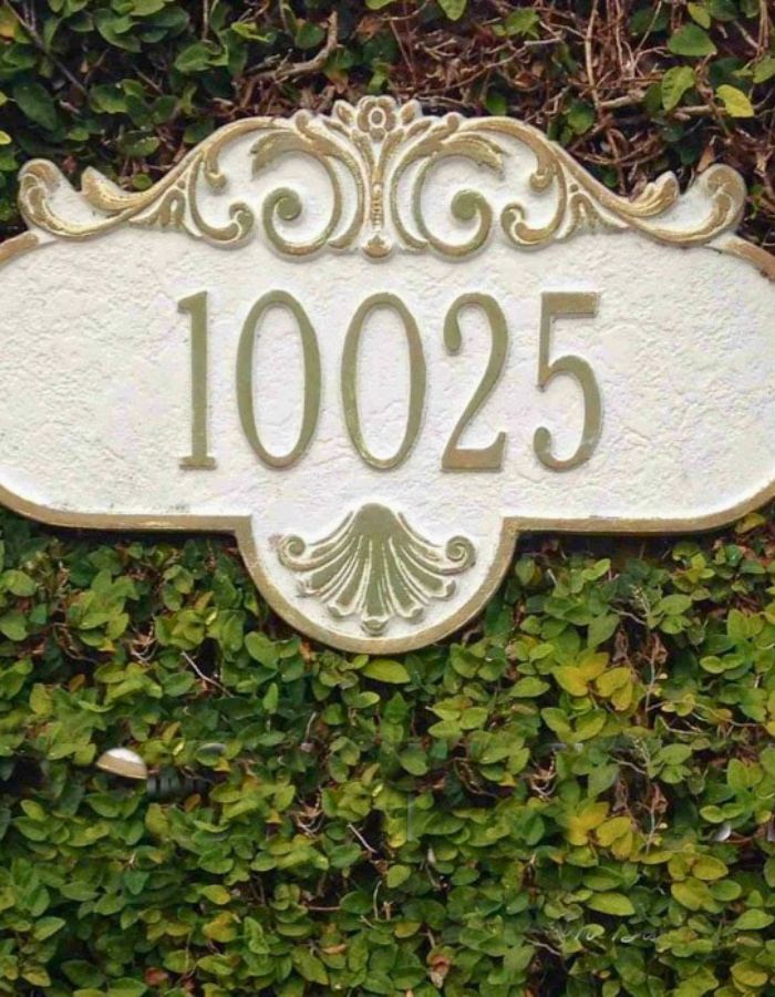 Close-up of ivy trimmed neatly around brick mailbox house numbers