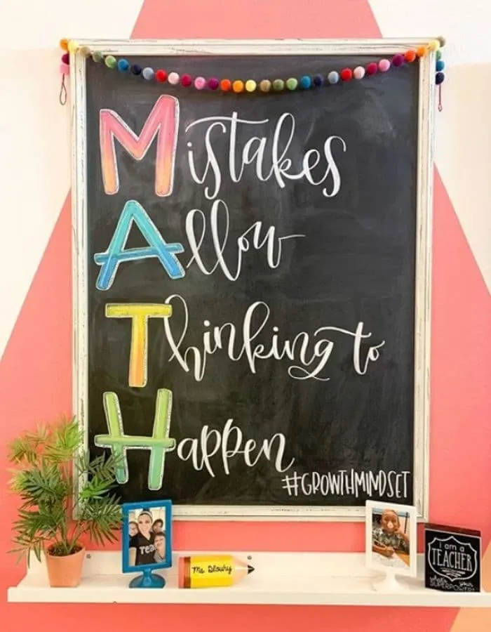 a long vertical chalkboard hanging with the text MATH, Mistakes Allow Thinking to Happen, written