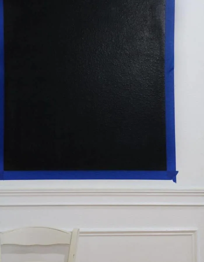 This is an up close image of the painters tape on the wall and the freshly painted chalkboard.