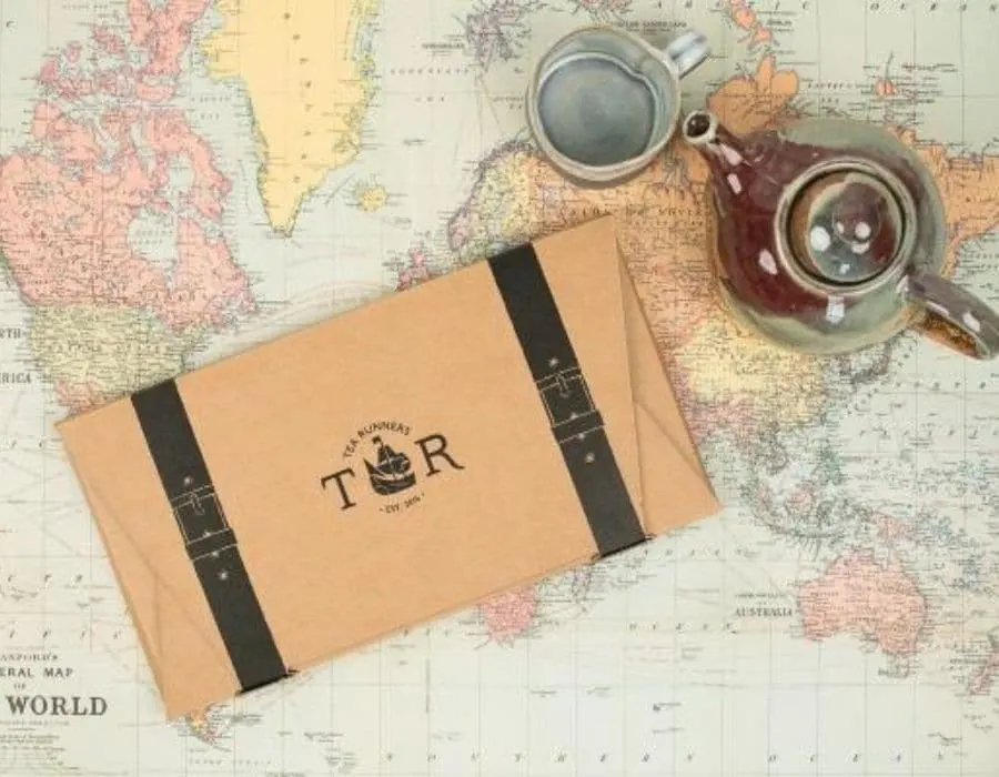 Tea Runners monthly loose leaf tea gift subscription on top a world map with a tea pot next to it.