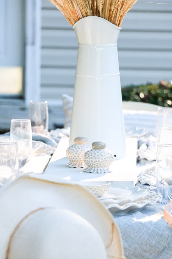 Fall table runner idea of a wood board painted in white chalkpaint with a milk pitcher on it with wheat.