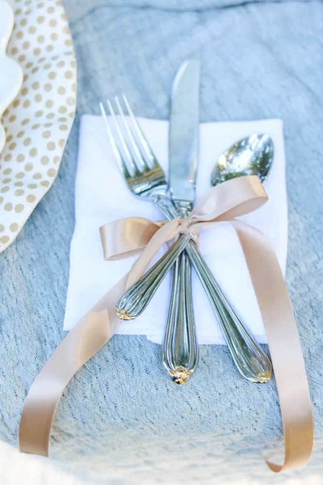 Silverware wrapped in ribbon and tied in a tow for a fall or Thanksgiving tablescape