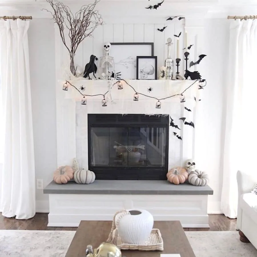Halloween fireplace decorations in black and white and ravens, skeletons, bats, garland, candles.
