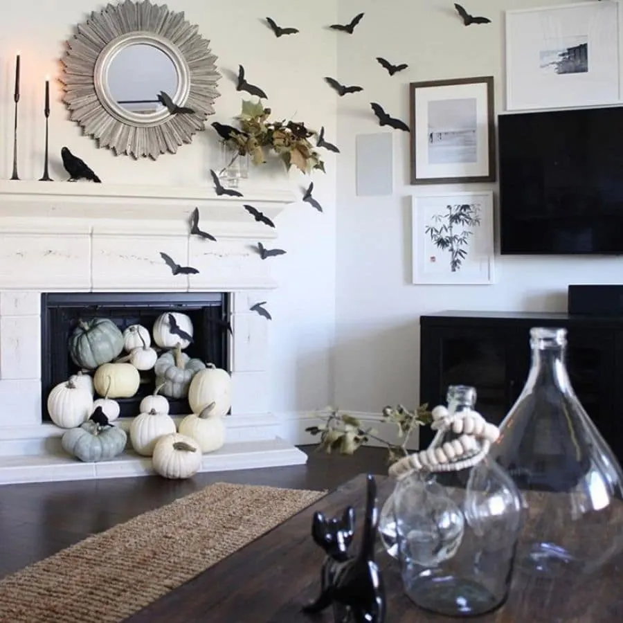 Halloween decorations for mantle with bats, pumpkins, ravens and black candles.