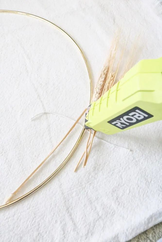 Place a dot of hot glue ton the wire ring where you will be tying the dried wheat in place.