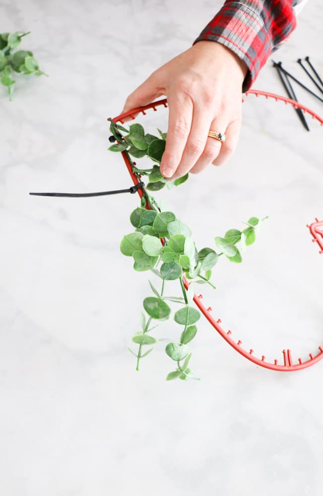 Add greenery to this DIY Dollar Tree heart wreath