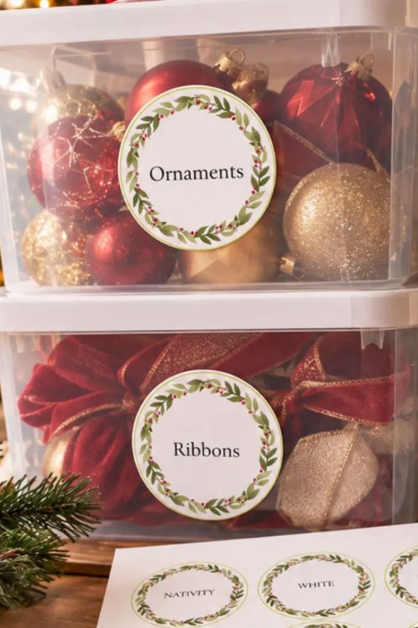 Editable Christmas storage labels with a green wreath on clear bins of ornaments and ribbons