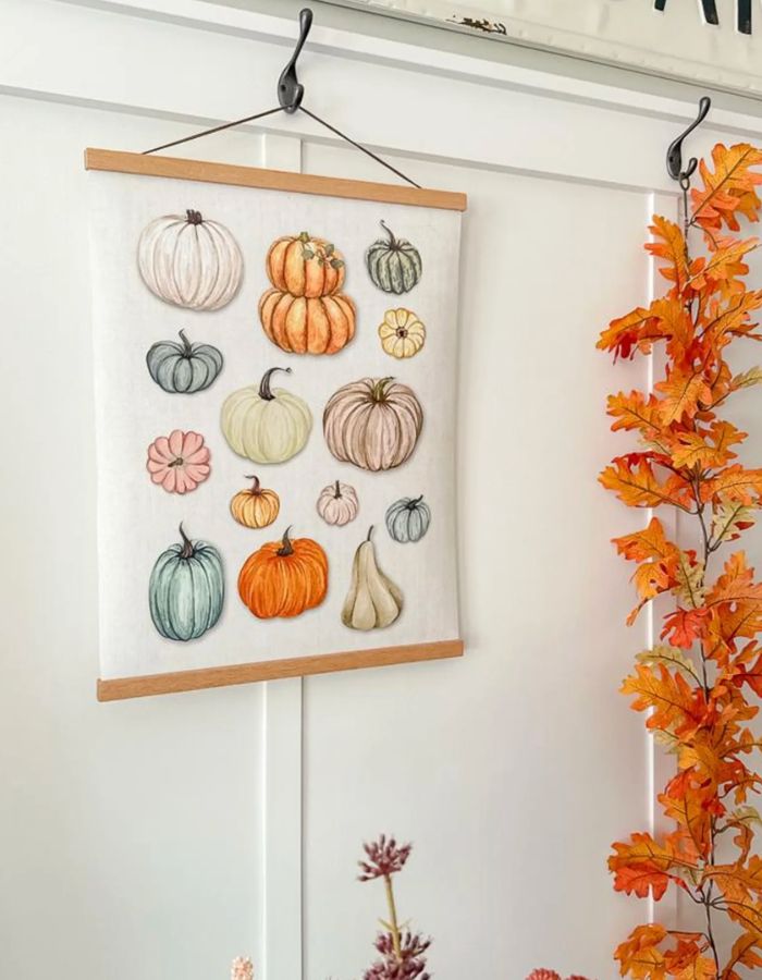 Fall printable wall art ideas colorful pumpkin print on canvas paper hung on wood hanger for fall home decor