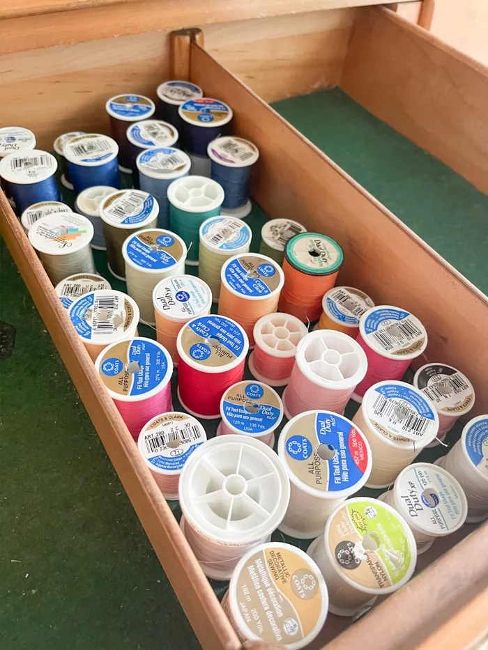 Organizing sewing supplies by rainbow color from left to right