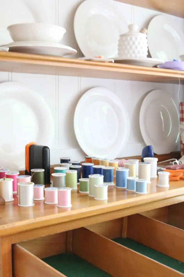 how to organize sewing supplies on a budget by placing all the spools of thread on the counter first.