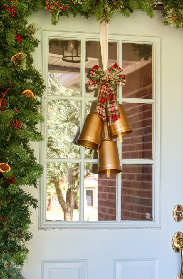 DIY bells on a farm house Christmas decorated porch