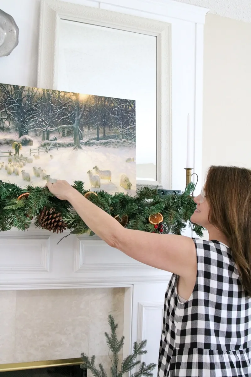 Hanging a Christmas garland on a mantel