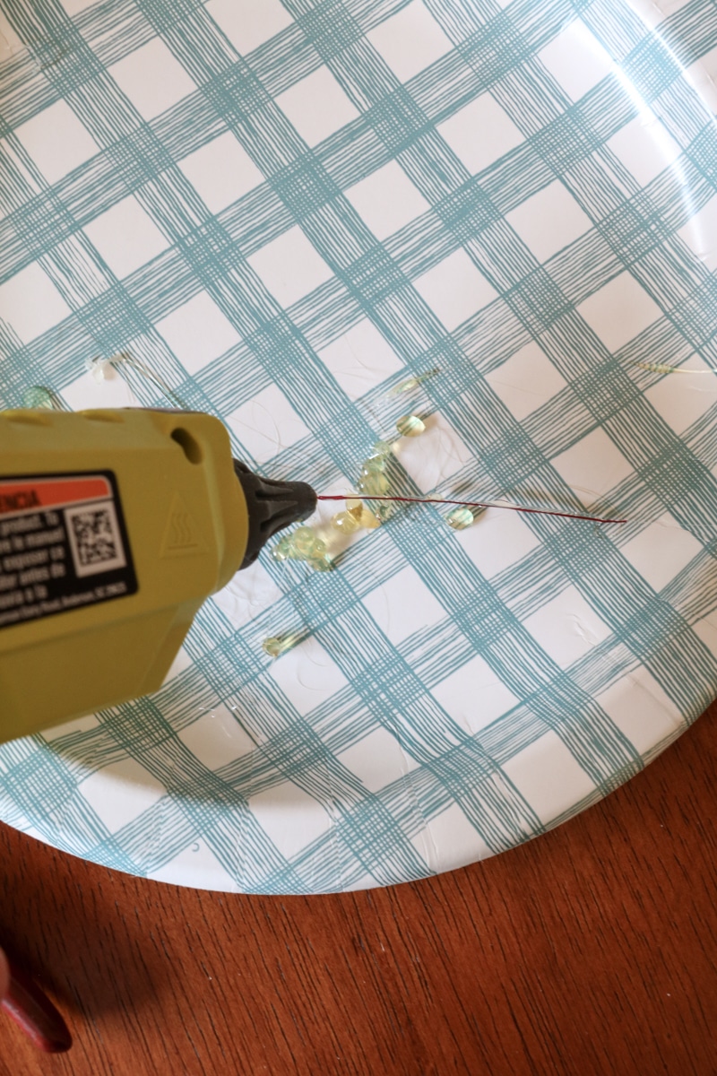 Add glue to wire to attach to a paper leaf