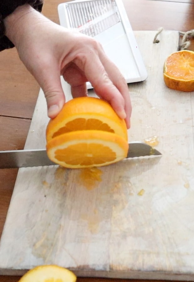Cutting orange slices to dry for home decor