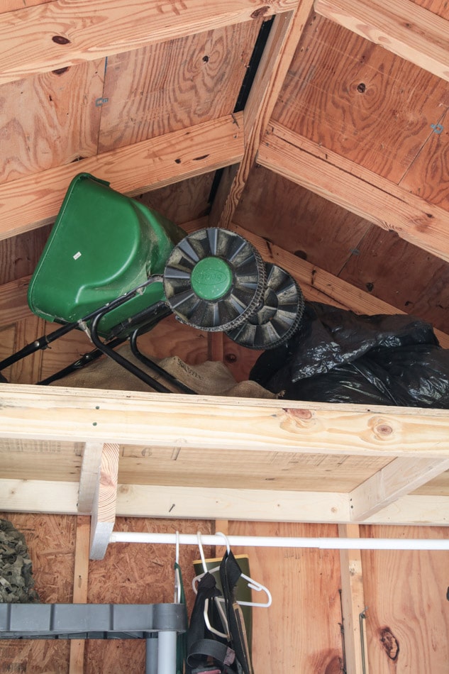 How to organize a shed showing a gardening spreader in the loft