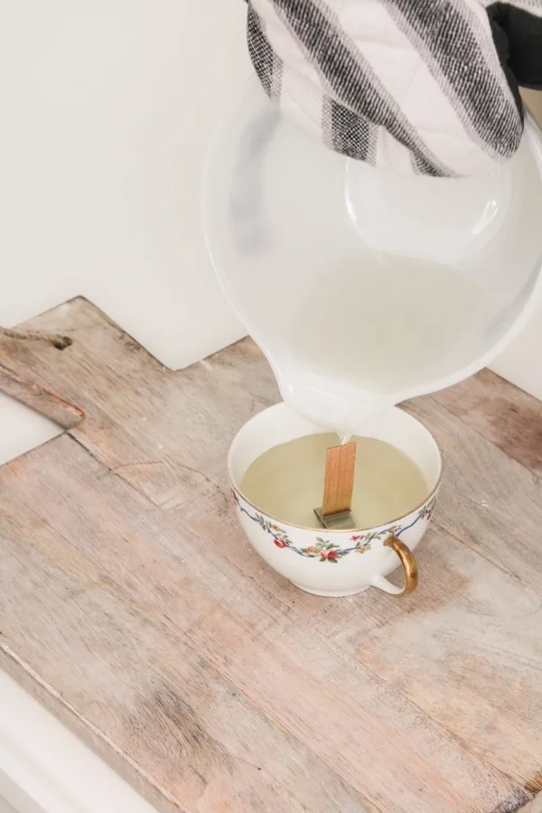 Pouring beeswax into a teacup to make a candle