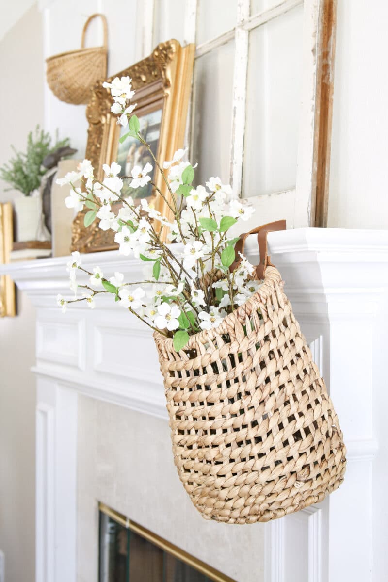 Hanging basket on end of fireplace mantel filled with spring flowers of dogwood
