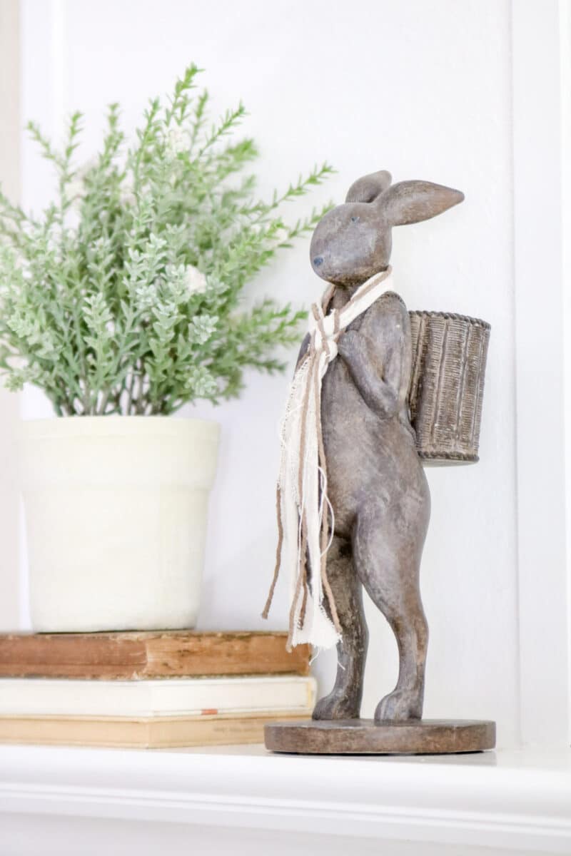 Vintage rabbit sculpture with basket on his back and standing with a scarf around his neck