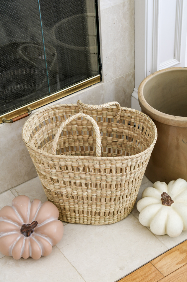 Decorating your living room for fall with pumpkins and baskets on a hearth