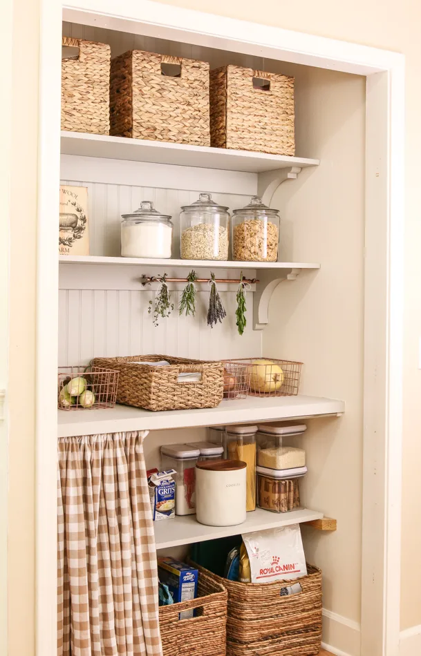 Organizing a pantry with wicker baskets, wire baskets, glass jars and hidden storage