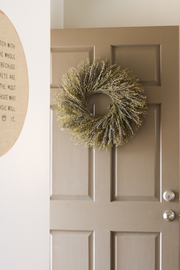 Dried lavender wreath hanging on brown painted door