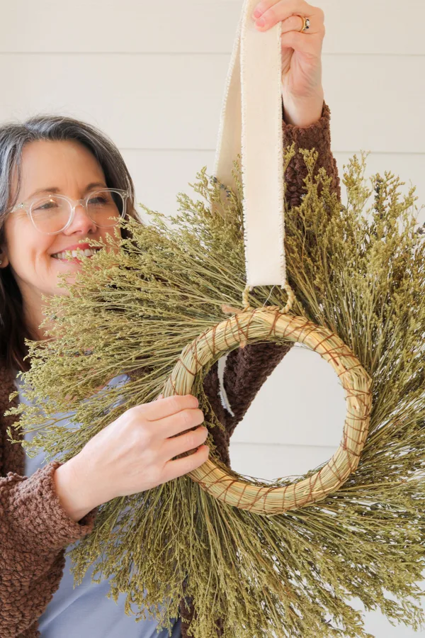 Adding ribbon to a wreath to hand on a glass storm door