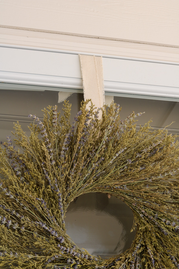 Close up of wreath hanging with ribbon over storm door