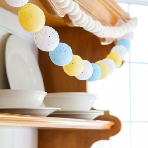 DIY Easter egg garland hanging on a hutch