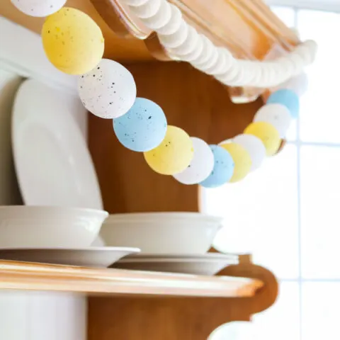 DIY Easter egg garland hanging on a hutch