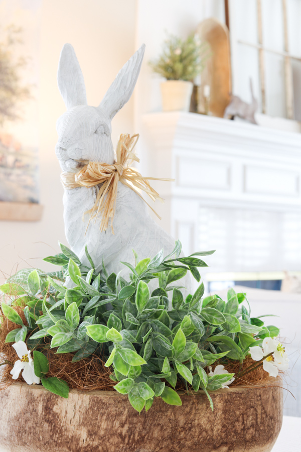 Easter centerpiece with white bunny in dough bowl full of plants and flowers