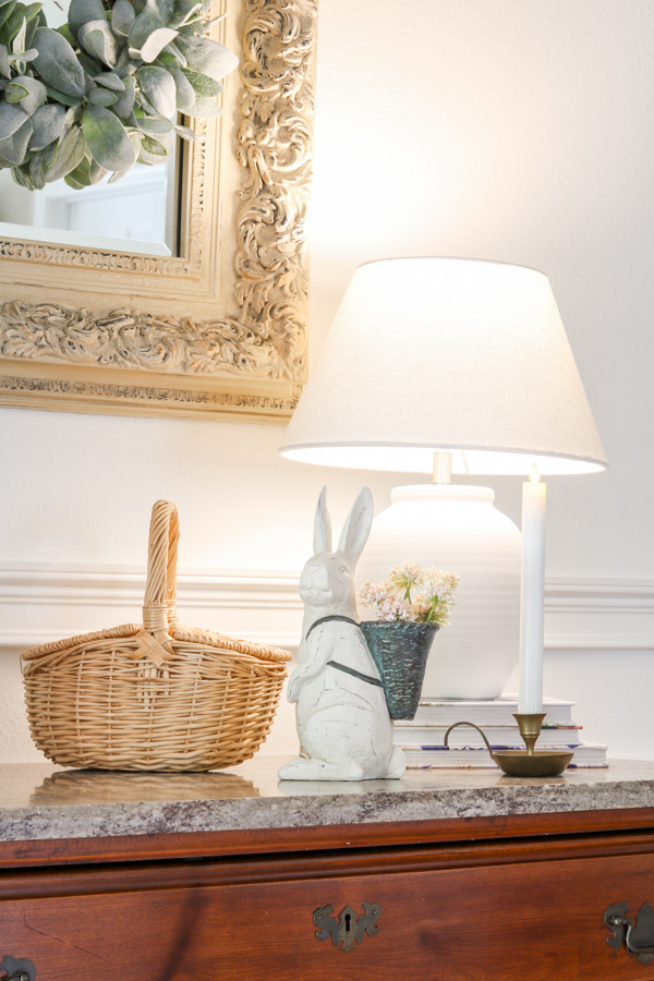 Entryway table spring decoration idea of a bunny with basket backpack and wicker basket