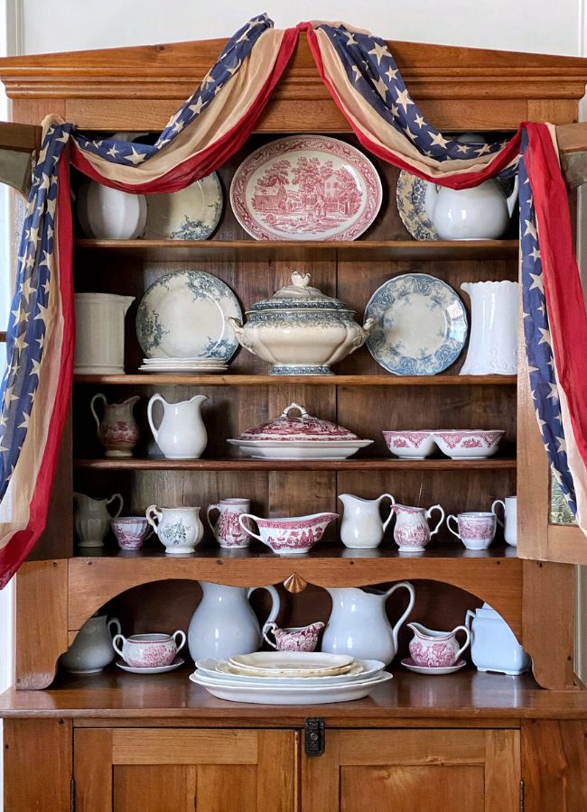Vintage swag on hutch filled with red, white and blue transferware