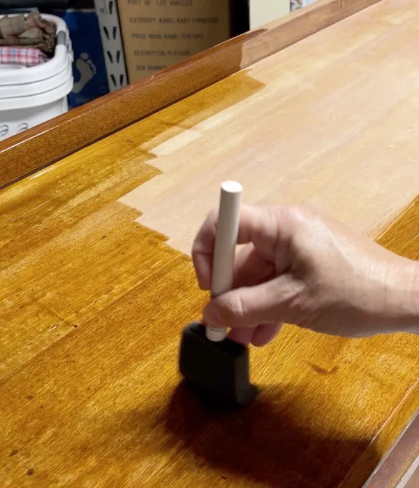 Applying stain to furniture with sponge brush and stain