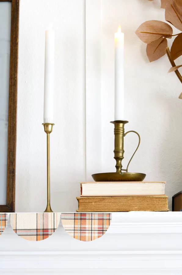 Add warm color to your home decor for fall with candles on a fireplace mantel