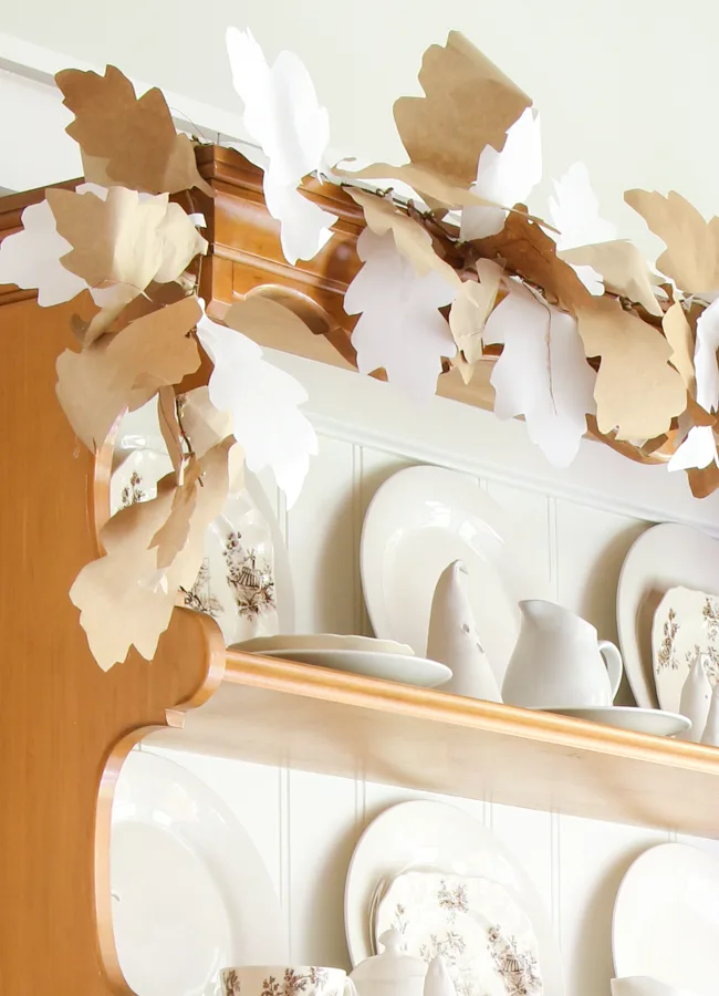 DIY paper leaf garland to go with clay ghosts for a vintage Halloween decorations on a hutch