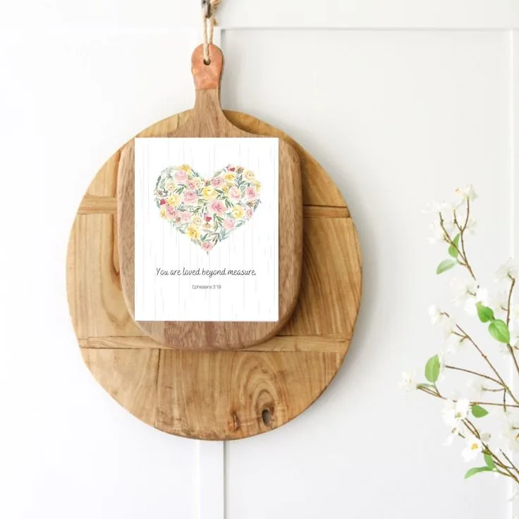 Valentine printable of flowers shaped into a heart and a bible verse under the heart that says "You are loved beyond measure."