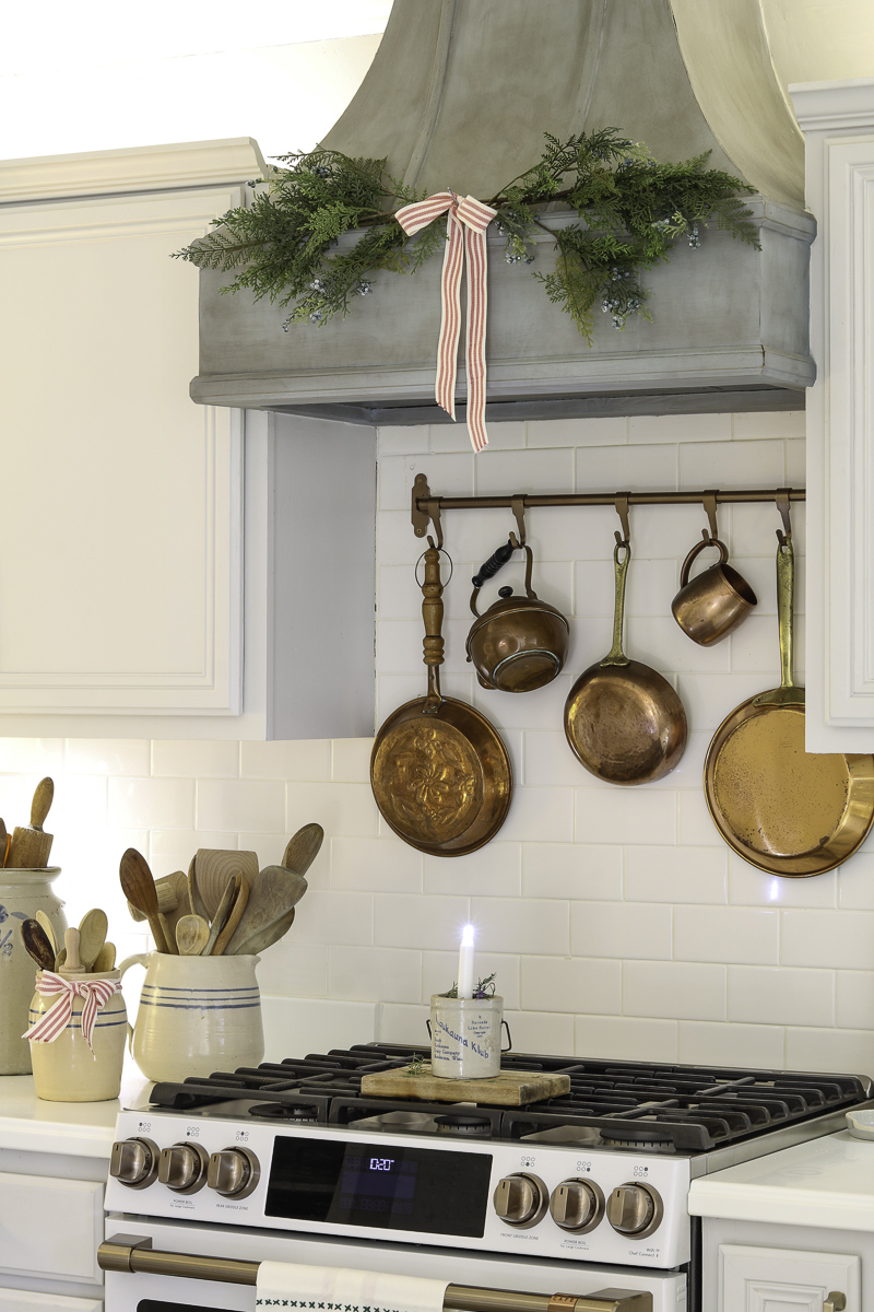 Mini garland on range hood over stove with red and white ribbon bow.