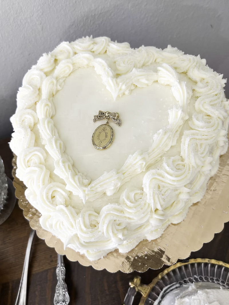 Bridal shower cake for an enchanted garden party.  Heart shaped cake with white frosting and vintage locket