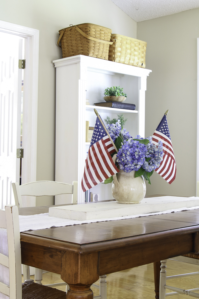 Dining room decorating for the 4th of July with a patriotic centerpiece ironstone pitcher filled with hydrangeas and American flags