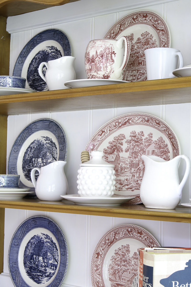 Blue Currier and Ives dishes, red transferware dishes and white create a patriotic design for the hutch